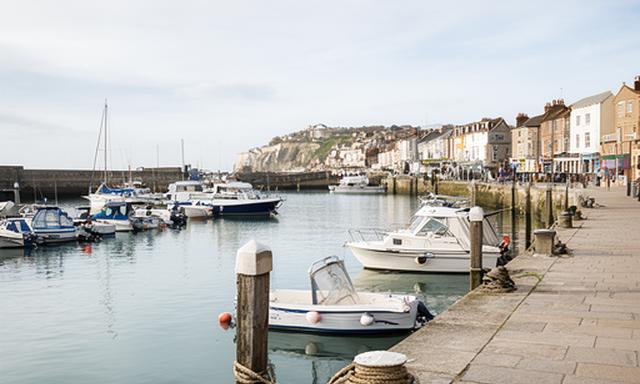 View of the marina in Dover, Kent, with boats beside the waterfront promenade